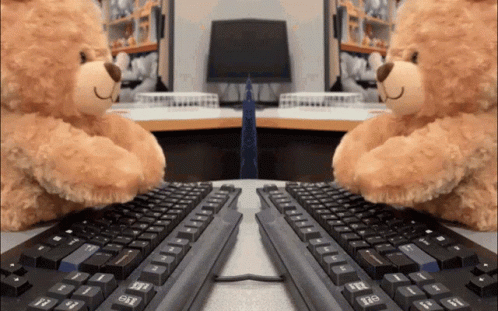 two teddy bears are sitting in front of a keyboard with the shift key on the left side