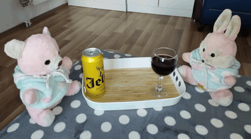 Two Teddy Bears Are Sitting Next To A Tray With A Can Of Jel On It GIF