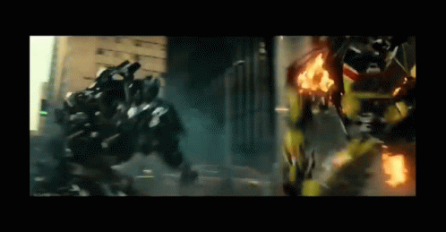 Two Transformers Are Fighting Each Other In A City While A Car Is On Fire . GIF