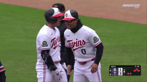 two twins baseball players talking on the field