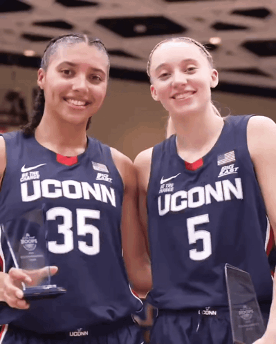 Two Uconn Basketball Players Are Holding Trophies GIF