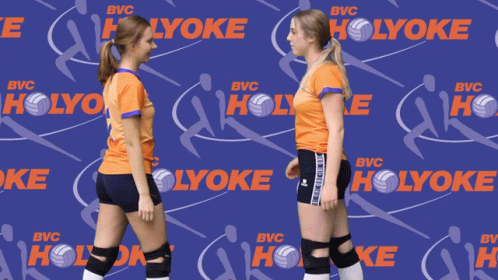 Two Volleyball Players Holding Hands In Front Of A Holyoke Background GIF