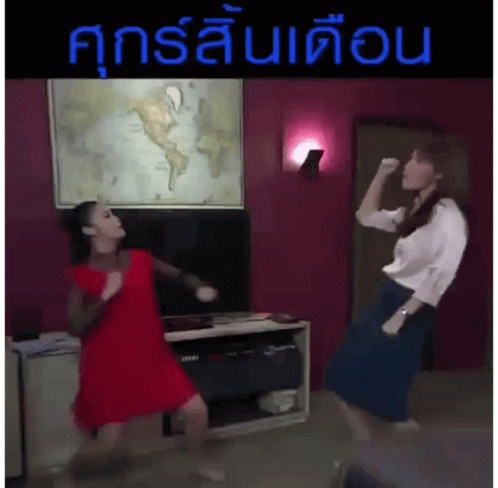 Two Women Are Dancing In Front Of A Map Of The World In A Living Room .. GIF