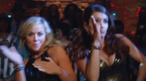 Two Women Are Dancing Together In A Club And One Of Them Is Covering Her Face With Her Hand . GIF