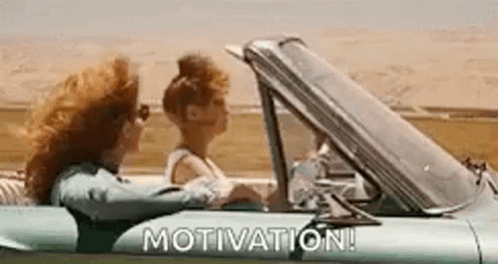 Two Women Are Driving A Car With The Words `` Motivation '' Written On It . GIF