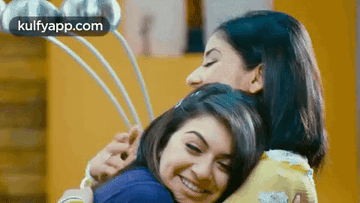 Two Women Are Hugging Each Other In A Room And The Words Kulfyapp.com Are Visible In The Corner . GIF