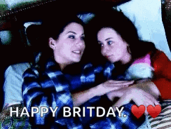 Two Women Are Hugging Each Other In Bed With The Words Happy Britday Written Above Them . GIF