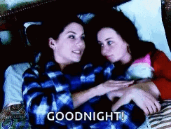 Two Women Are Laying In Bed Hugging Each Other And The Words `` Goodnight '' Are Written On The Bottom . GIF