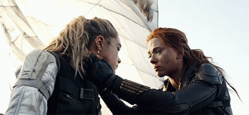 Two Women Are Looking At Each Other And One Is Holding The Other 'S Hand GIF