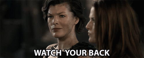 Two Women Are Looking At Each Other And The Words Watch Your Back Are Visible GIF