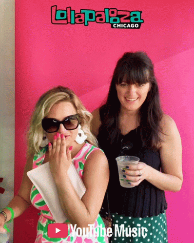 Two Women Are Posing For A Photo In Front Of A Pink Background That Says Lollapaloza Chicago GIF