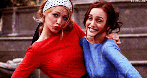 Two Women Are Posing For A Picture Together And One Is Wearing A Red Top And The Other Is Wearing A Blue Top . GIF