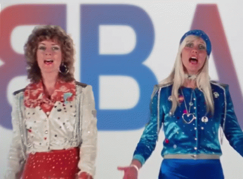 Two Women Are Singing In Front Of A Large Letter B GIF