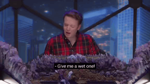 Two Women Are Sitting At A Table Talking To Each Other And One Of Them Says Give Me A Wet One . GIF