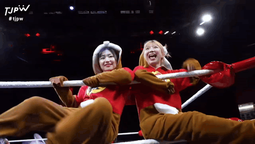 Two Women Are Sitting In A Boxing Ring With The Tjpw Logo On The Bottom GIF