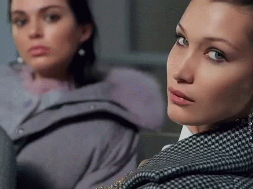Two Women Are Sitting Next To Each Other And One Is Wearing A Plaid Jacket GIF