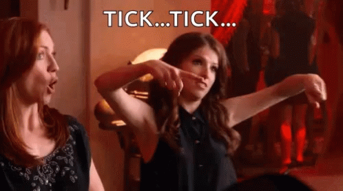 Two Women Are Sitting Next To Each Other And One Of Them Is Pointing At The Other With The Words Tick ... Tick ... Writt GIF