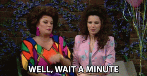 Two Women Are Sitting Next To Each Other And One Of Them Is Saying Well Wait A Minute GIF
