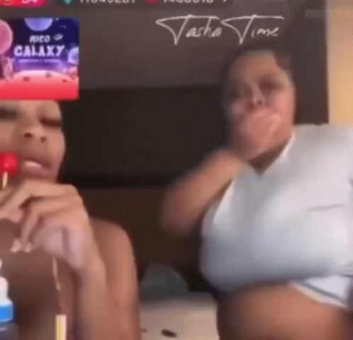 Two Women Are Sitting Next To Each Other In Front Of A Screen That Says ' Galaxy ' On It . GIF