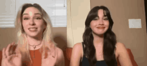 Two Women Are Sitting Next To Each Other On A Couch And Talking To Each Other . GIF