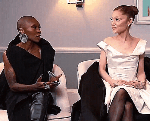 Two Women Are Sitting Next To Each Other On A Couch Talking To Each Other . GIF