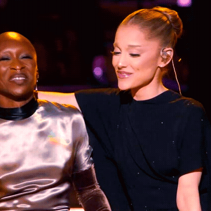 Two Women Are Sitting Next To Each Other On A Stage And Looking At Each Other . GIF