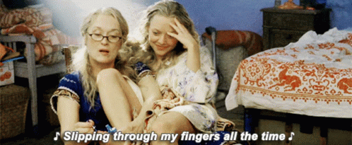 Two Women Are Sitting Next To Each Other With The Words " Slipping Through My Fingers All The Time " Above Them GIF