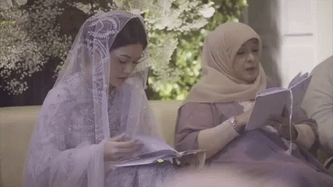 Two Women Are Sitting On A Couch Reading Books . GIF