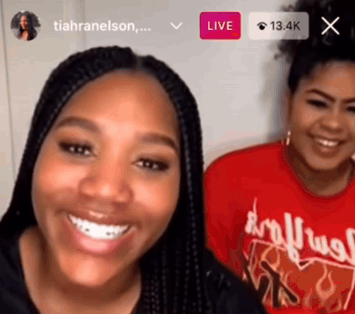 two women are smiling in front of a screen that says live on it