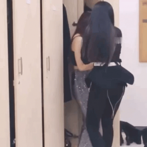 two women are standing in a locker room .
