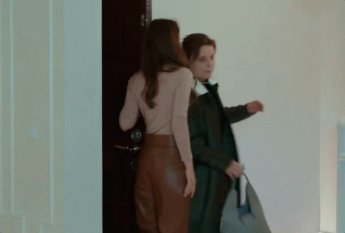 two women are standing in front of a blue door
