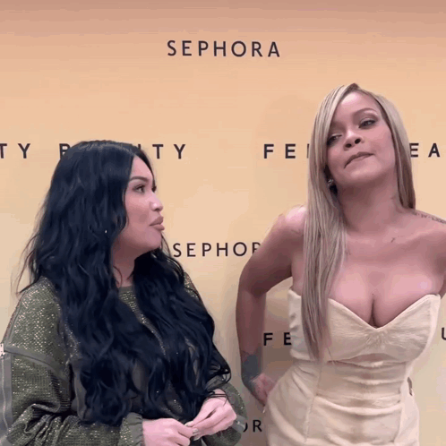 Two Women Are Standing In Front Of A Wall That Says Sephora GIF