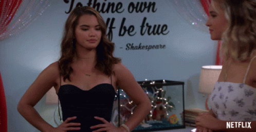 Two Women Standing In Front Of Shine Own If Be True Wall GIF