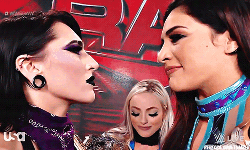 Two Women Are Standing Next To Each Other And One Has A Bandana With The Word Usa On It GIF