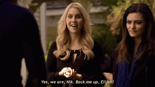 Two Women Are Standing Next To Each Other And One Of Them Is Saying Yes We Are Nik Back Me Up Elijah GIF