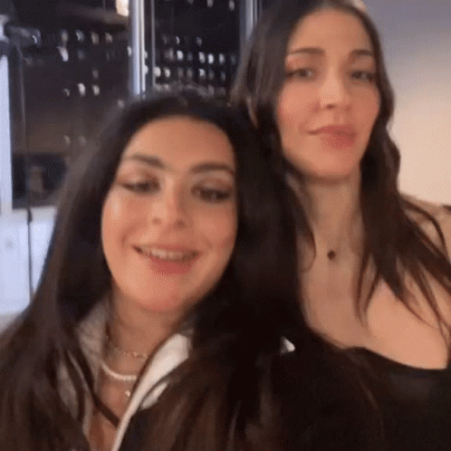 Two Women Are Standing Next To Each Other And Smiling . GIF