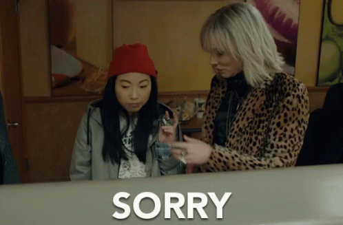 Two Women Are Standing Next To Each Other And The Word Sorry Is On The Counter GIF