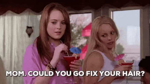 Two Women Are Standing Next To Each Other Holding Drinks And Talking . GIF