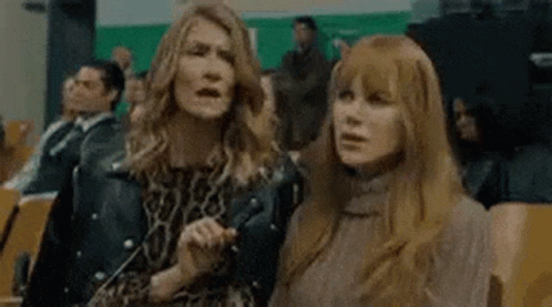 Two Women Are Standing Next To Each Other In A Crowd Of People . GIF
