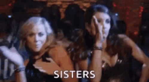 Two Women Are Standing Next To Each Other In A Dark Room And The Word Sisters Is Written On The Screen . GIF