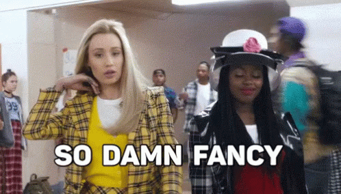 Two Women Are Standing Next To Each Other In A Hallway And One Of Them Is Wearing A Yellow Plaid Jacket . GIF
