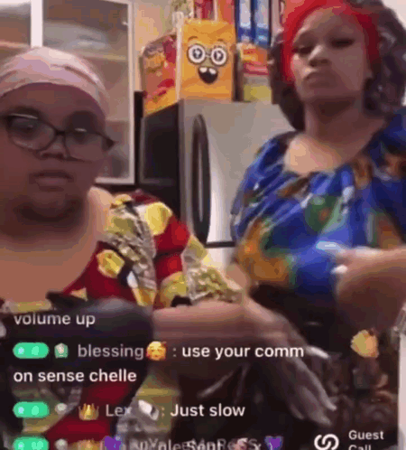 Two Women Are Standing Next To Each Other In A Kitchen And One Of Them Is Holding A Bottle Of Water . GIF
