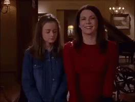 Two Women Are Standing Next To Each Other In A Room . GIF