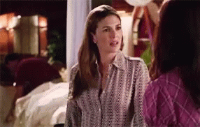 Two Women Are Standing Next To Each Other In A Room Talking To Each Other . GIF