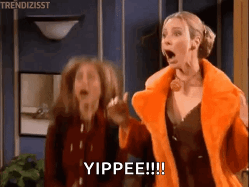 Two Women Are Standing Next To Each Other In A Room With Their Mouths Open And One Of Them Is Wearing An Orange Fur Coat GIF