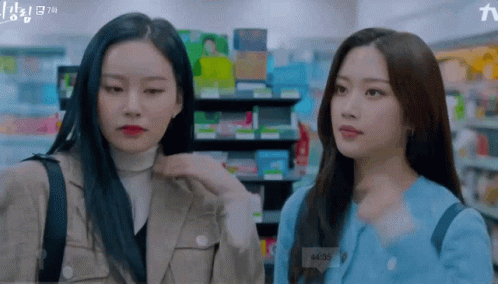 Two Women Are Standing Next To Each Other In A Store And One Of Them Has A Name Tag That Says A135 GIF