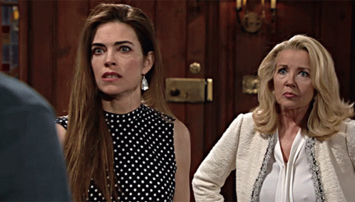 Two Women Are Standing Next To Each Other In Front Of A Door GIF
