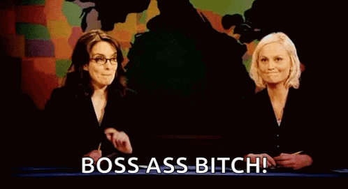 Two Women Are Standing Next To Each Other In Front Of A Map And A Sign That Says `` Bitches Get Stuff Done '' . GIF