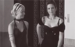 two women are standing next to each other in front of an elevator .