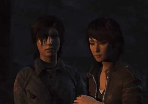 Two Women Are Standing Next To Each Other In The Dark GIF